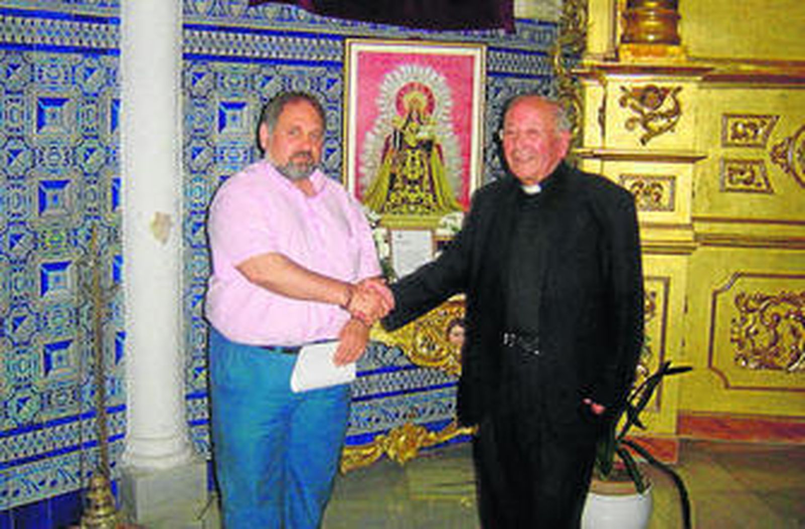 El párroco Sebastián Martín estrecha la mano a Agustín Romero.