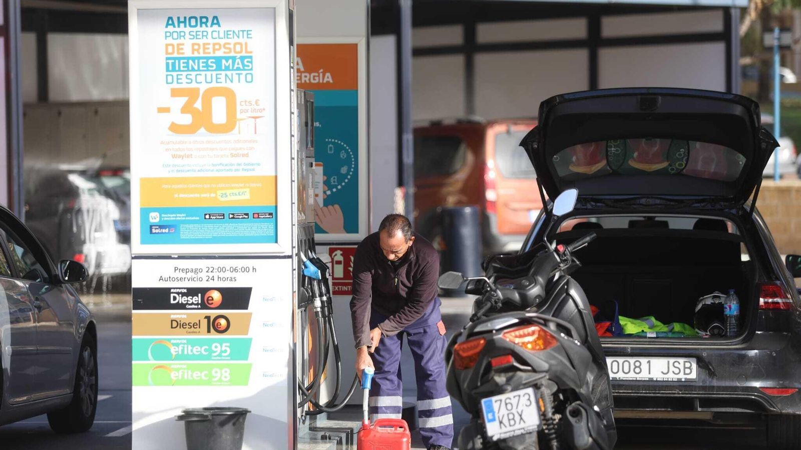 Un cliente rellena una garrafa de combustible.