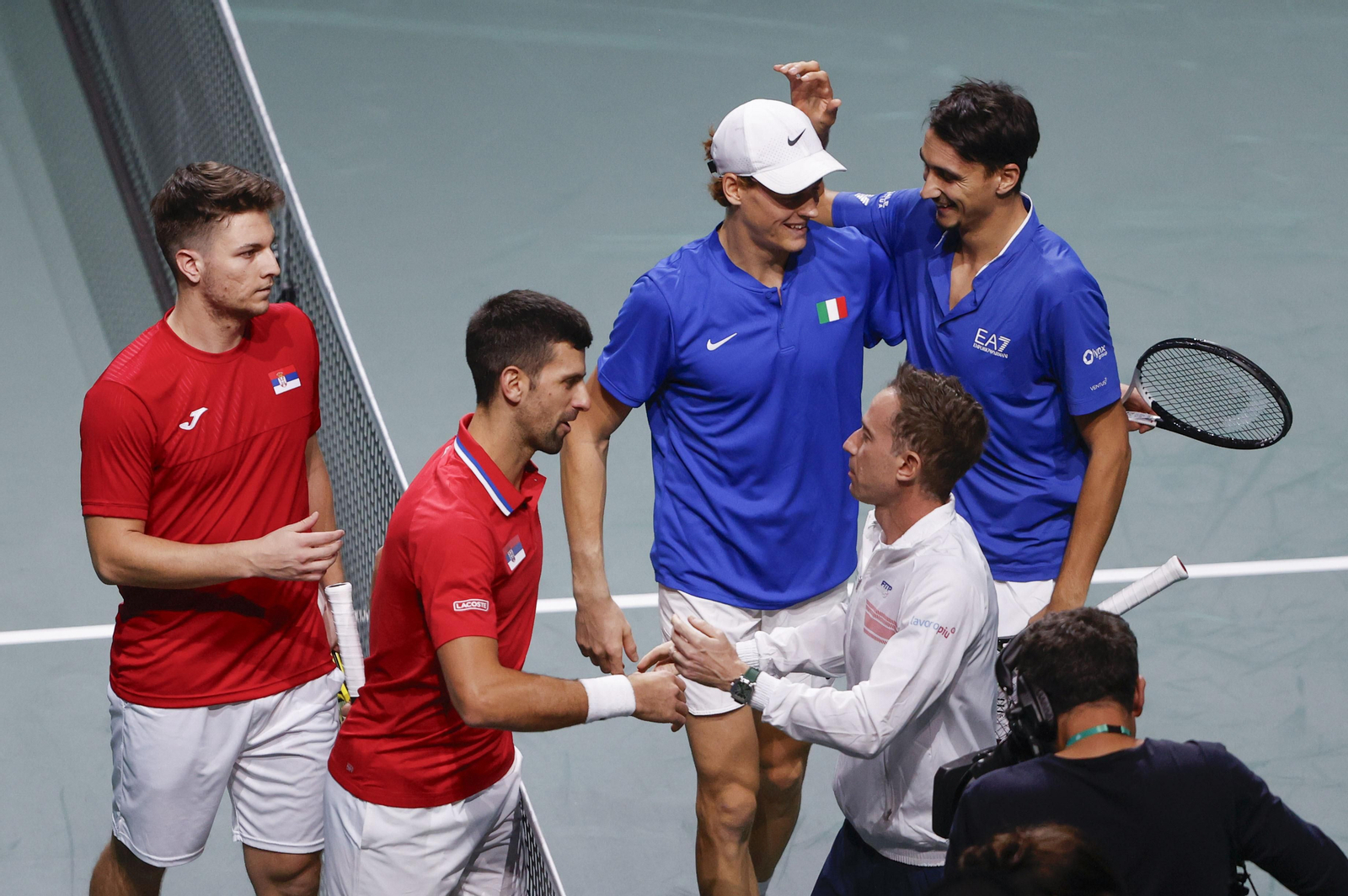 Italia y Serbia se saludan tras el partido de dobles.