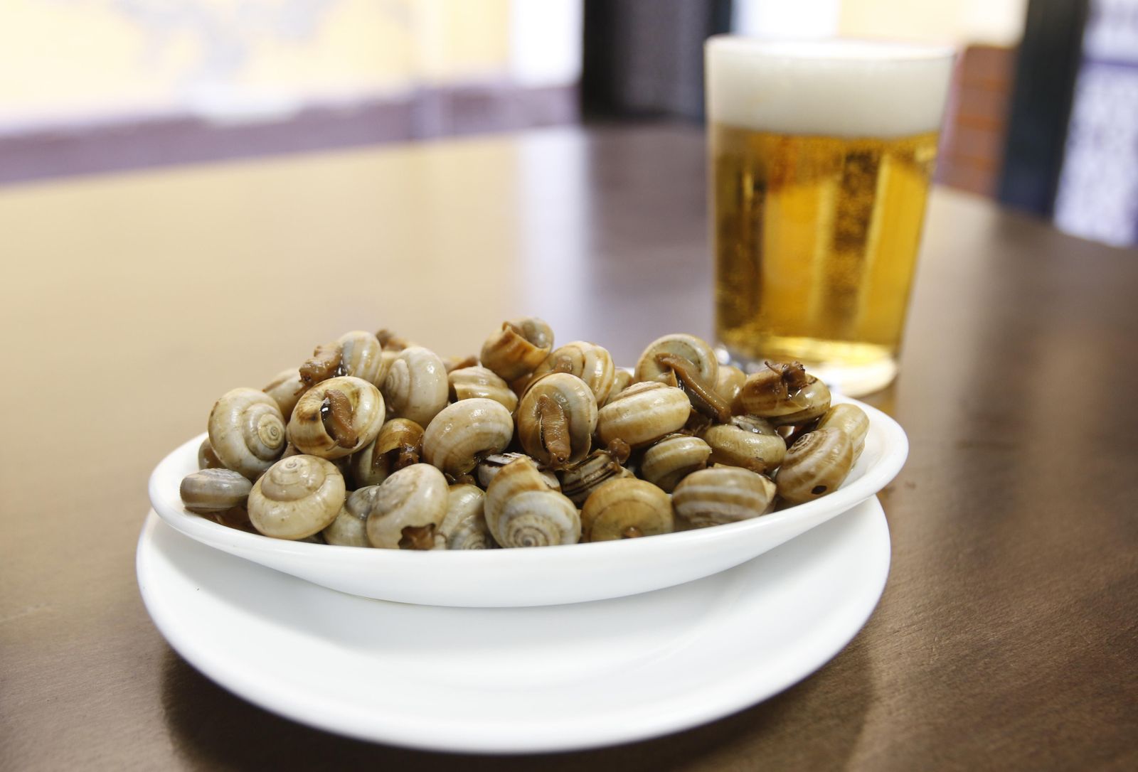 Una cerveza fresquita junto a una tapa de caracoles, combinación ganadora en estas fechas