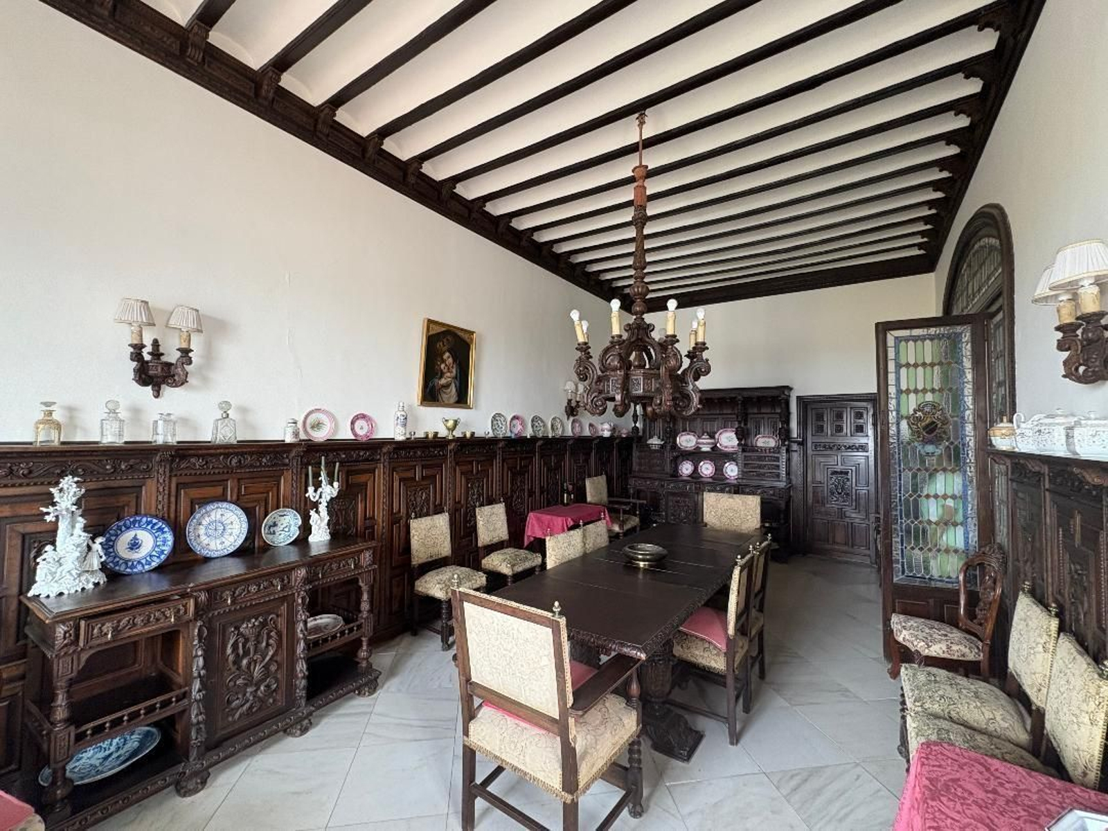 Comedor. Mobiliario de estilo español y puerta de vidriera emplomada.