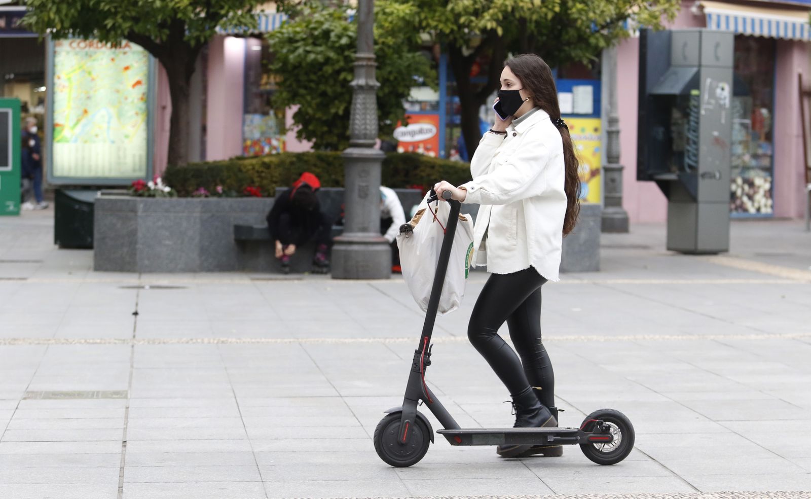 Una joven circula con un patinete por el centro de Córdoba.