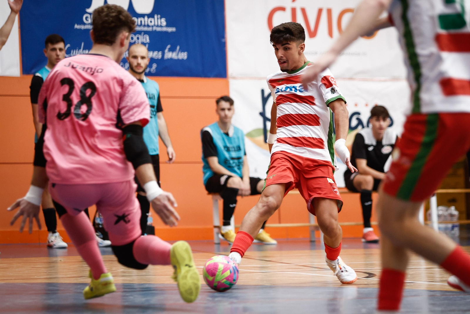 Un jugador del Sima Granada toca el balón ante la salida del portero rival.