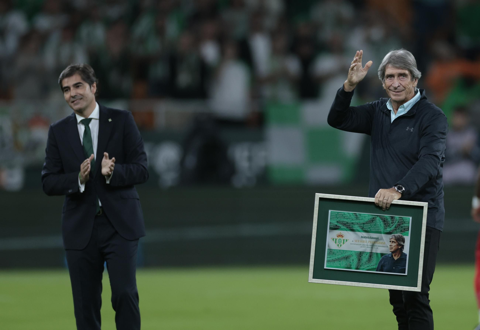 Manuel Pellegrini recibe de Haro el cuadro conmemorativo por su récord de 264 partidos como técnico y saluda a la afición.