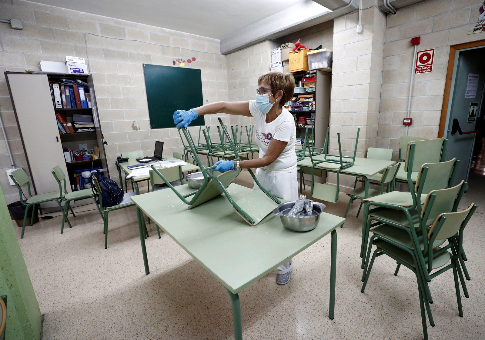 Una trabajadora procede a la limpieza de un comedor escolar.