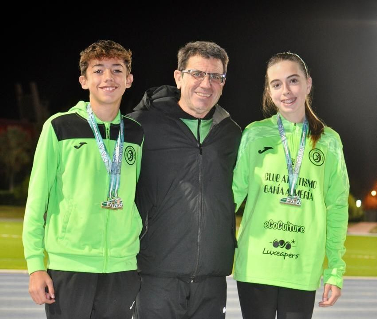 Los dos pertiguistas almerienses posan con sus medallas junto a su entrenador, Antonio Orta.