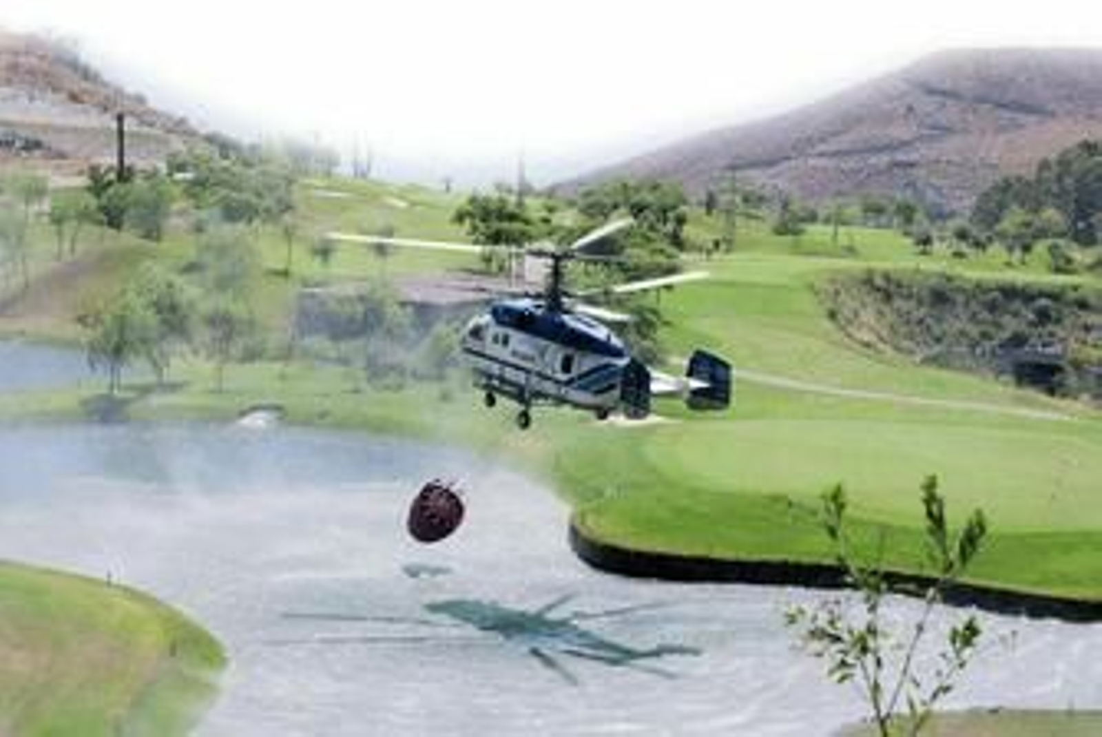 Un helicóptero coge agua del lago del campo de golf de Playa Macenas. Un helicóptero coge agua del lago del campo de golf de Playa Macenas.