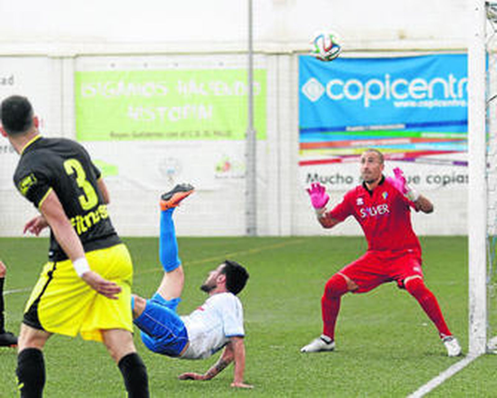 Aulestia, meta del Cádiz, intenta repeler el remate de chilena de Juanillo, que daría en el larguero.