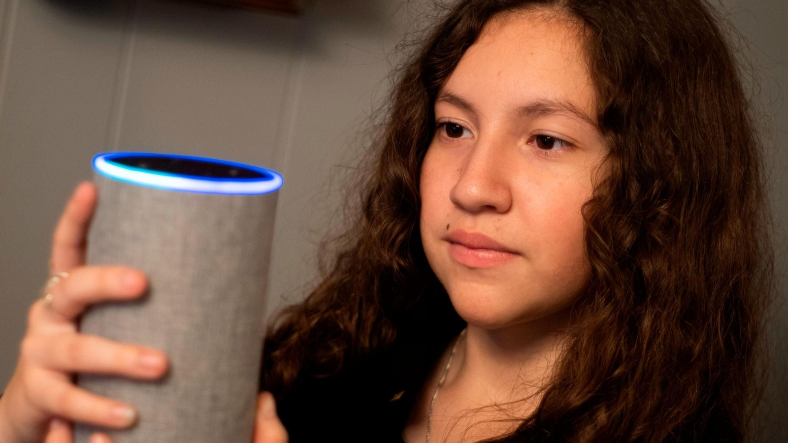 Una joven sostiene un dispositivo doméstico inteligente | Imagen de archivo