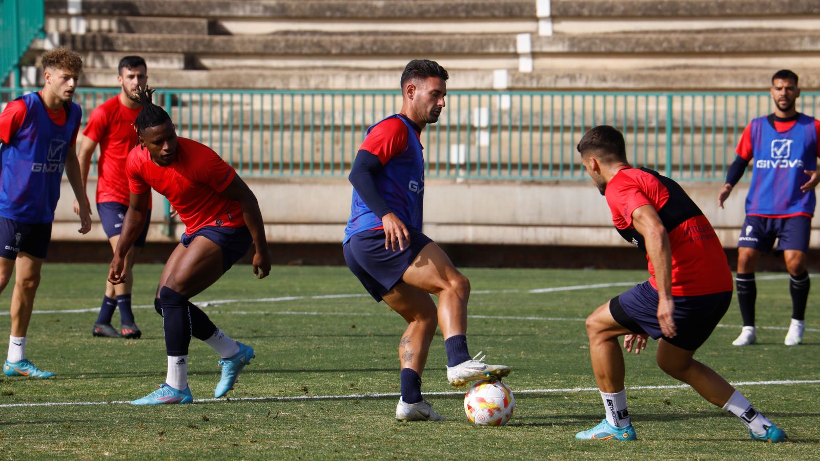 Kike Márquez pisa el balón entre Cedric Teguia y José Alonso, en un entrenamiento del Córdoba CF.