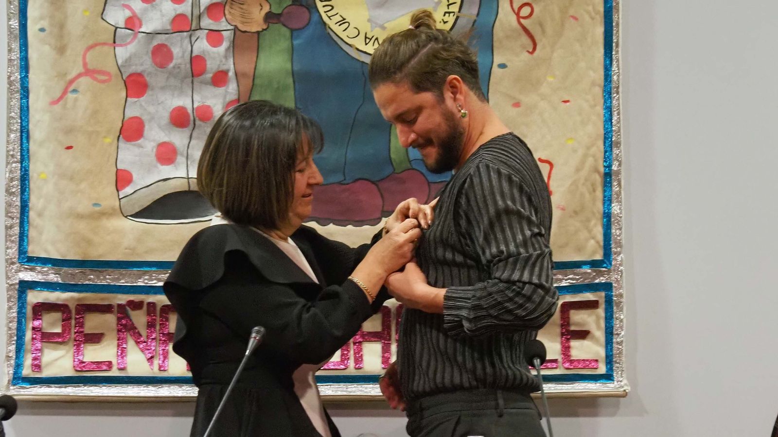 Momento en que la presidenta de la Peña, Pepi Garrido, impone el Antifaz de Oro a Manuel Carrasco