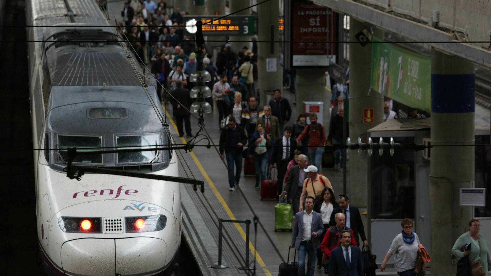 Llegada de un tren a la estación de Santa Justa, y sus viajeros a la derecha