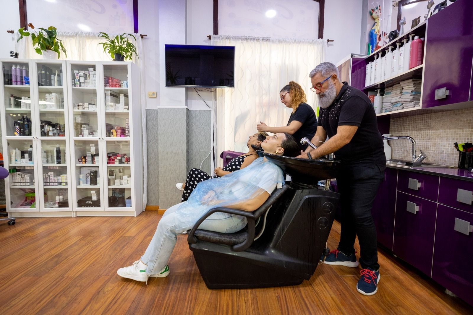 Cristino y su hija Violeta, trabajando en la peluquería este lunes.
