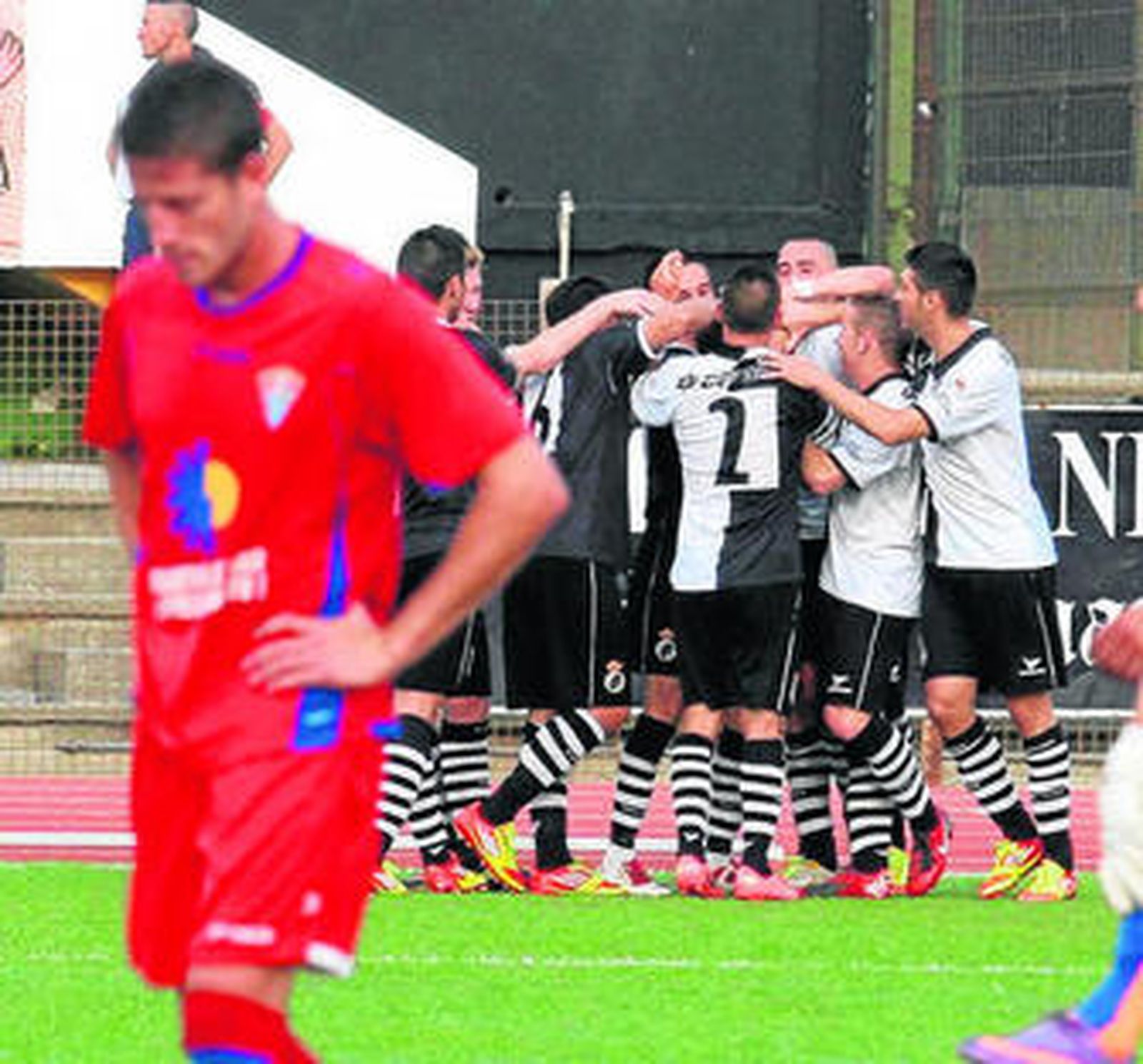 Los balonos celebran un gol ante la decepción de un jugador del Roquetas.