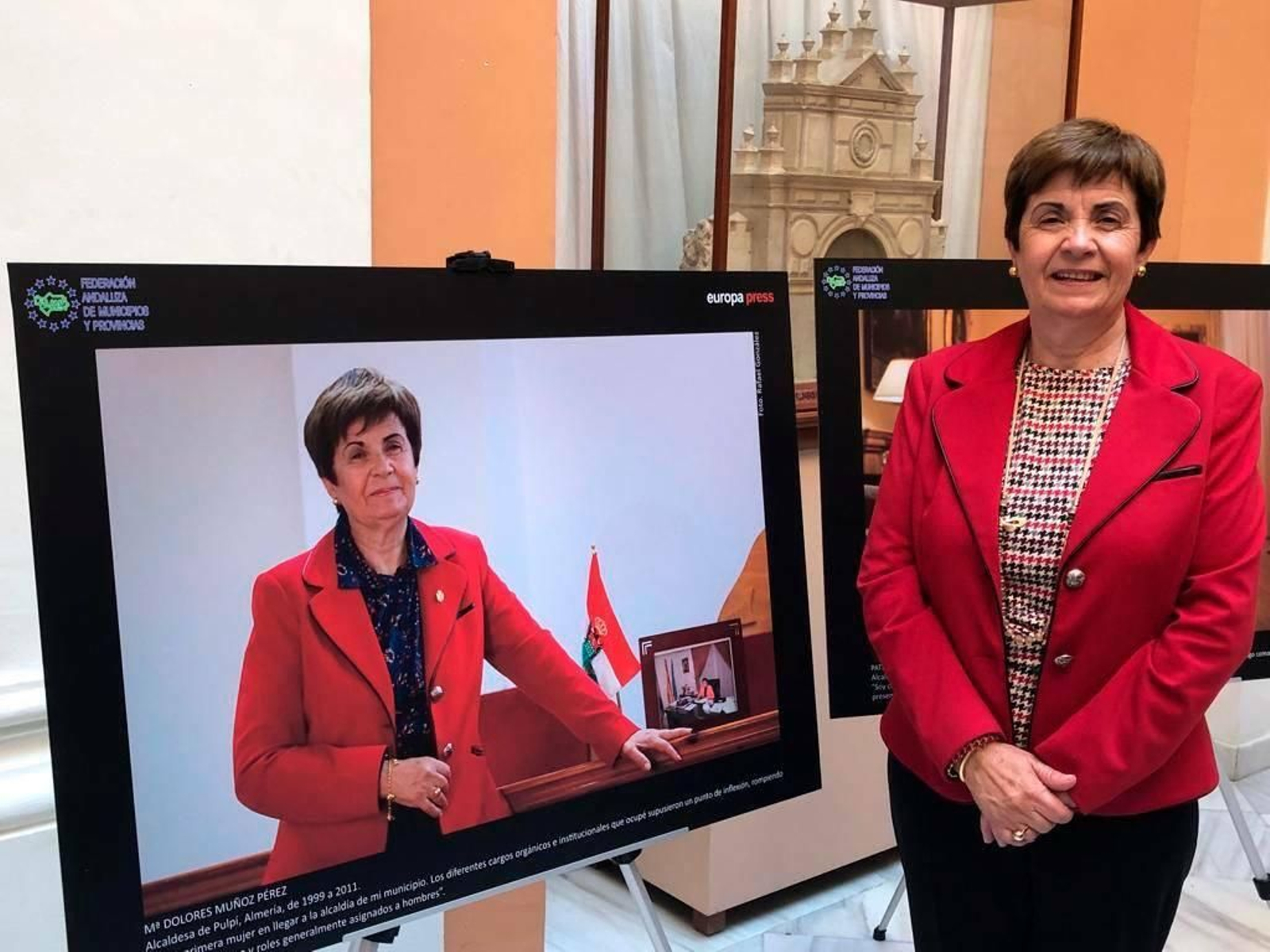 María Dolores Muñoz junto a su foto en la exposición.