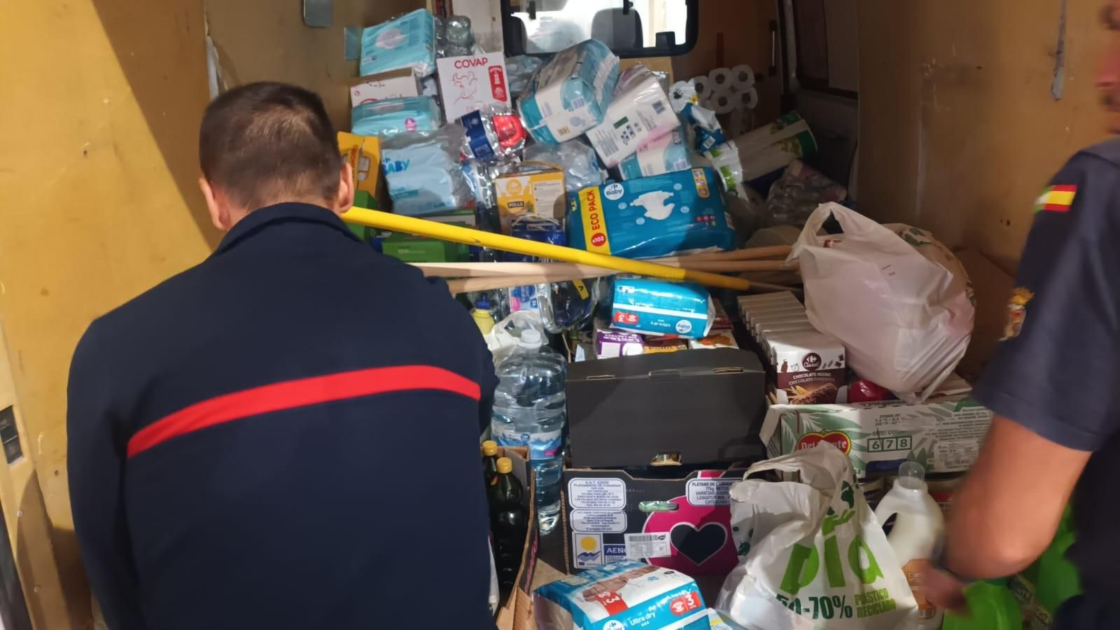 Un bombero junto a material recogido para enviar a Valencia