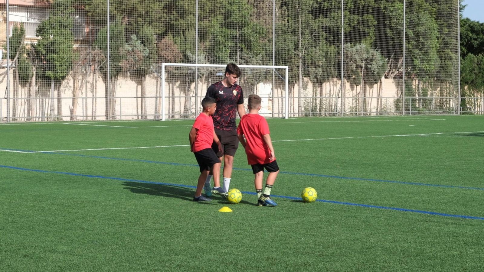Dos niños con el balón en los pies en el Campo de Fútbol de La Mojonera.