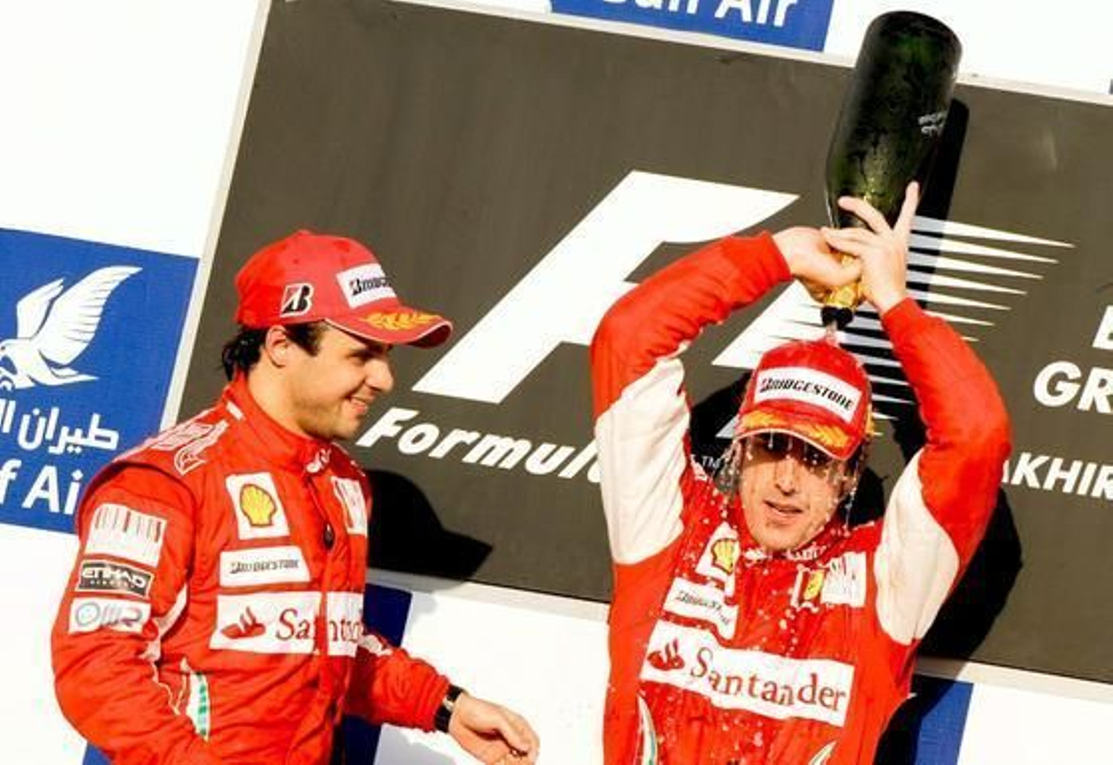 Alonso se echa el champagne por la cabeza en el podio. / EFE