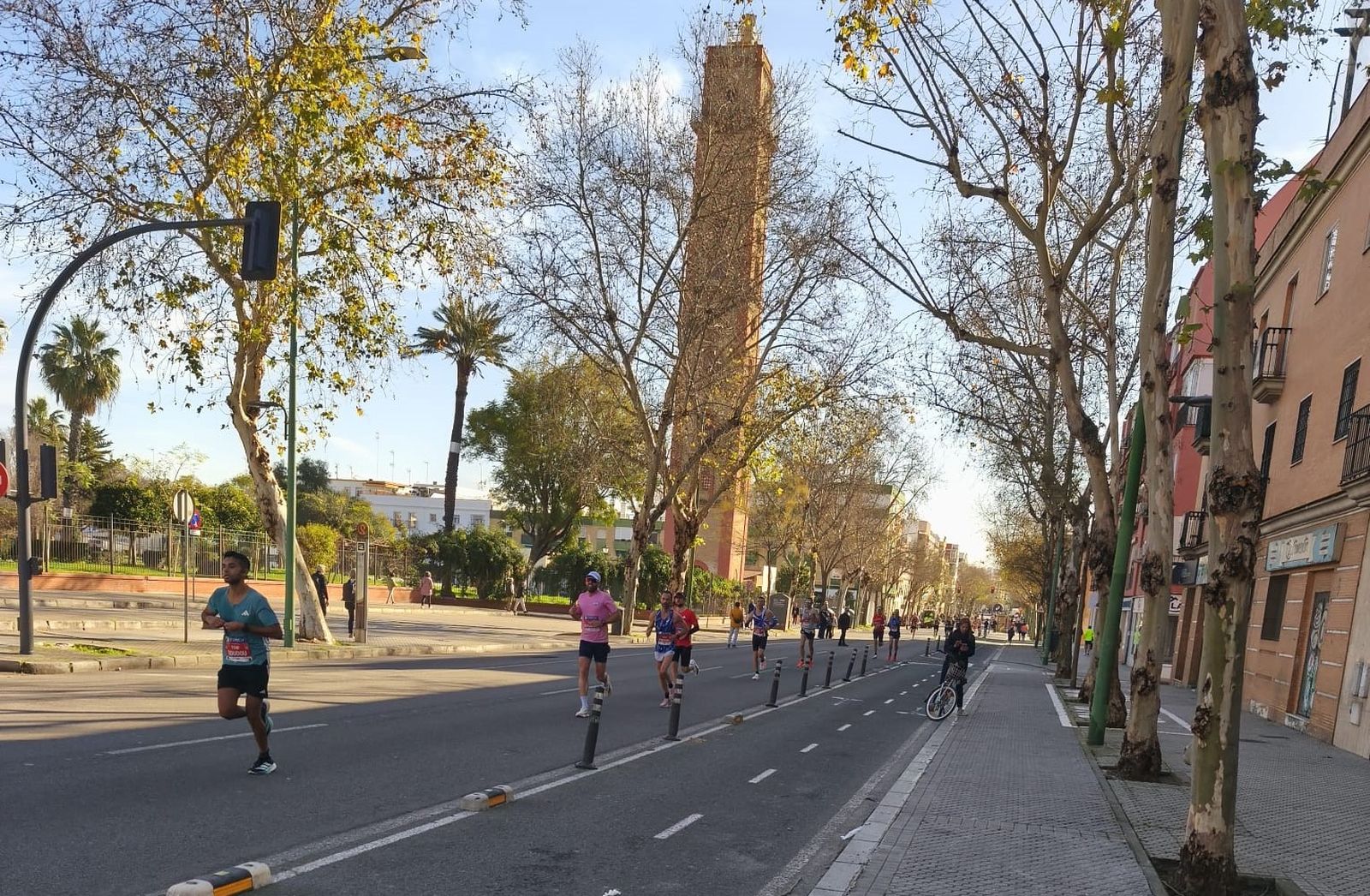 Los participantes en el maratón de Sevilla pasan junto a la Torre de los Perdigones.