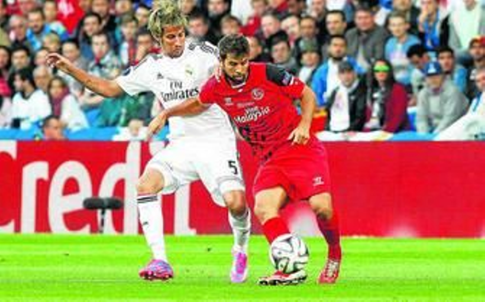 Coke golpea el balón con su pie derecho ante la presión de Coentrao.