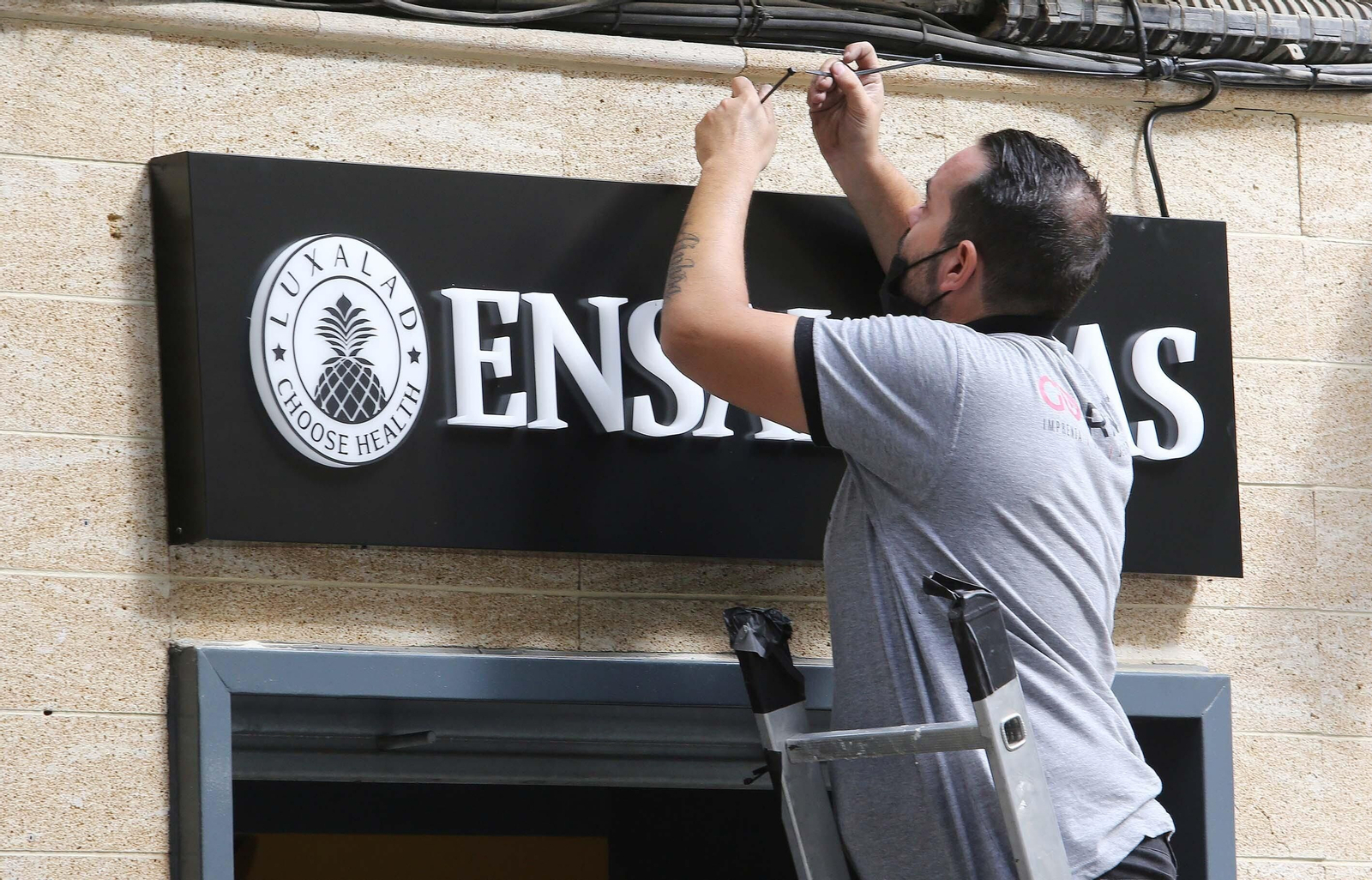 Un operario colocando el rótulo de la firma en la fachada del negocio, ayer por la mañana. Un operario colocando el rótulo de la firma en la fachada del negocio, ayer por la mañana.