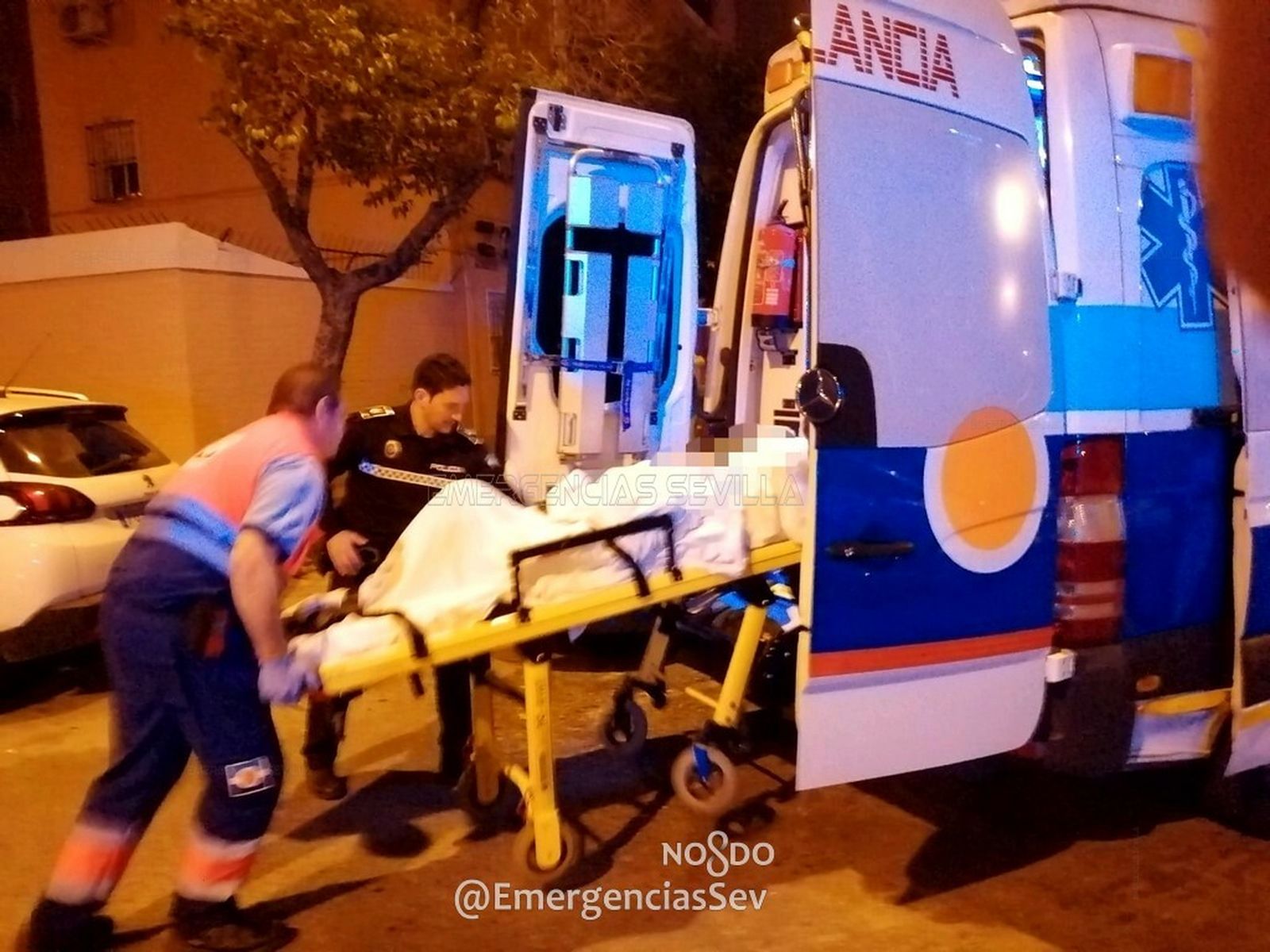 Los servicios sanitarios y la policía local introducen a la mujer en una ambulancia.