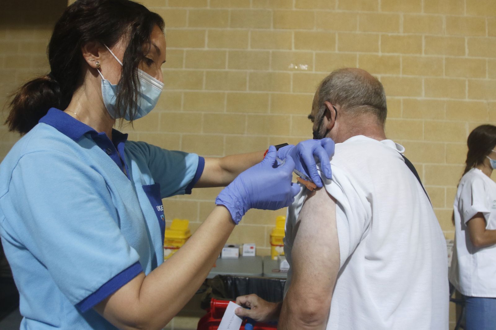 Una profesional sanitaria inyecta la vacuna contra el coronavirus a una persona.