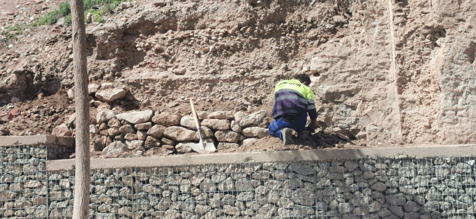 Uno de los trabajadores de Jarquil, recontruyendo el muro de contención de piedra.
