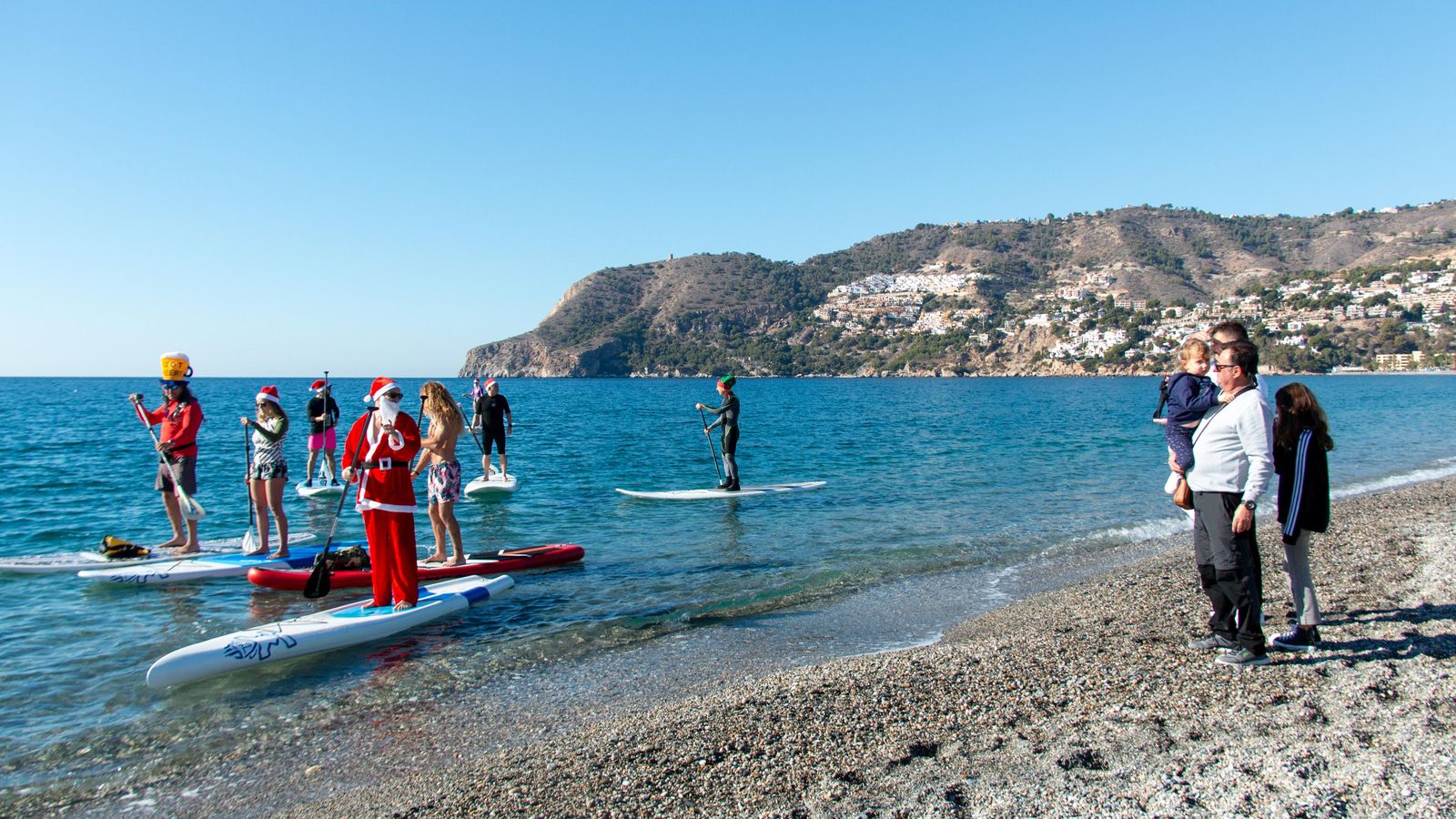 Una familia se acerca a la orilla para ver de cerca a Papá Noel Una familia se acerca a la orilla para ver de cerca a Papá Noel