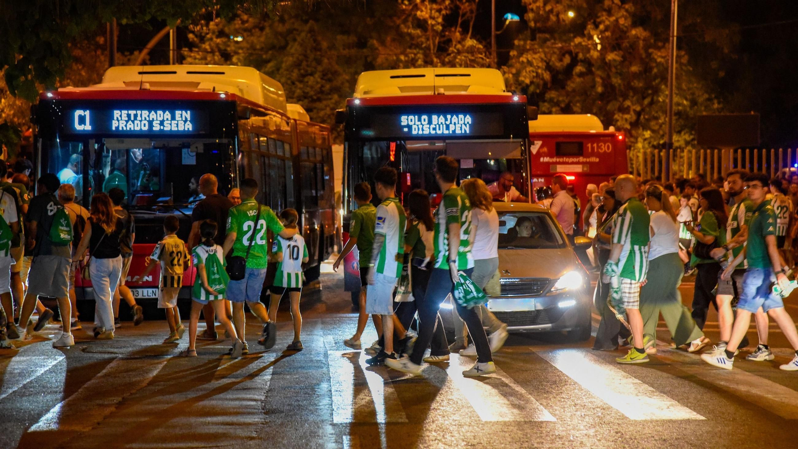 Tres autobuses, un coche y decenas de aficionados, en el tapón de la salida de Américo Vespucio hacia las paradas de autobús.