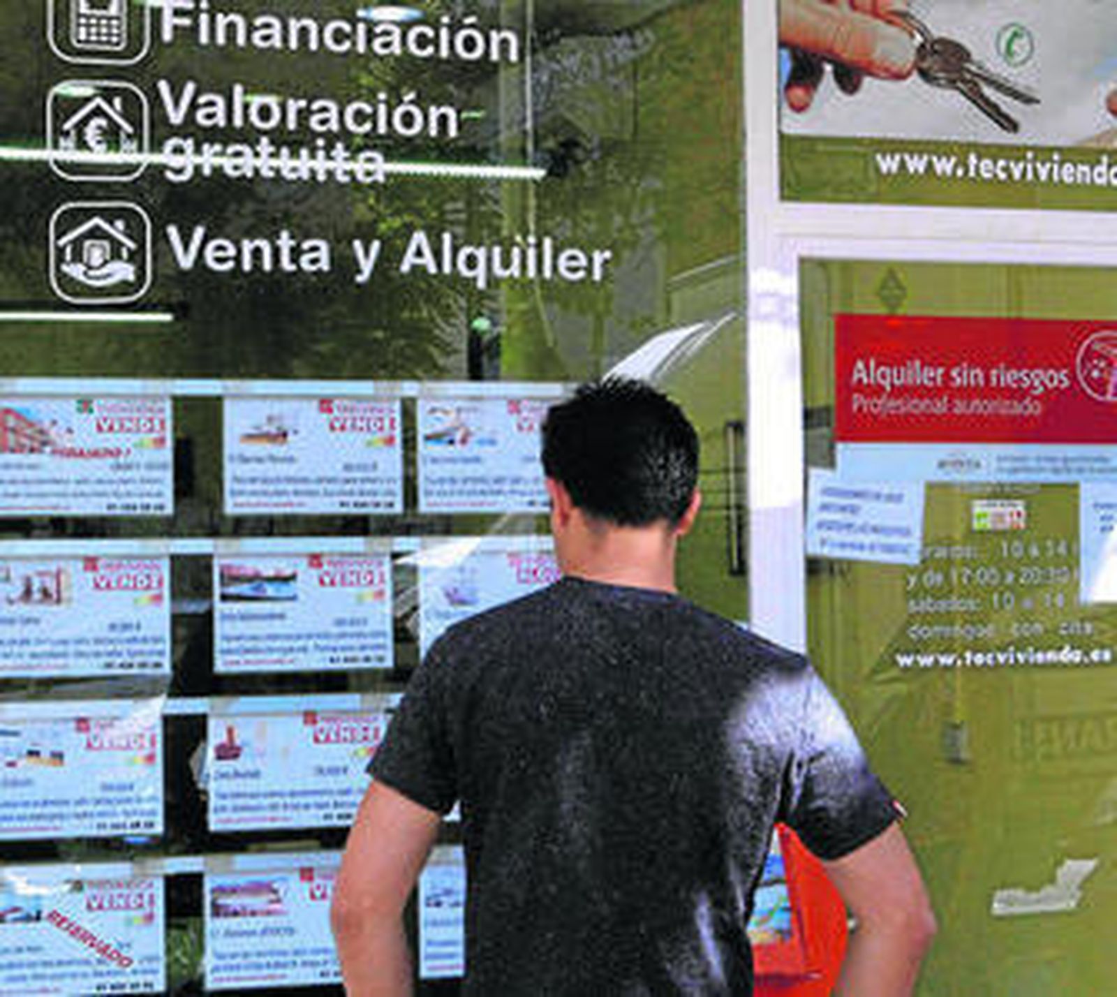 Un hombre observa el escaparate de una inmobiliaria.