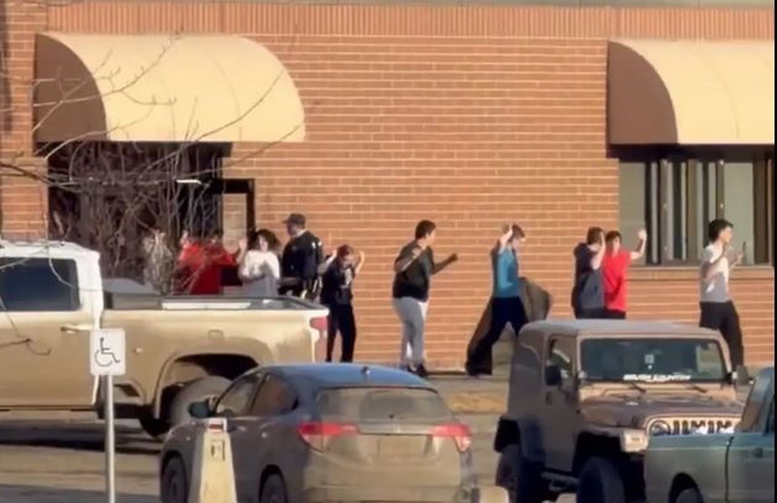 Alumnos de las escuela evacuándola con la manos en alto.