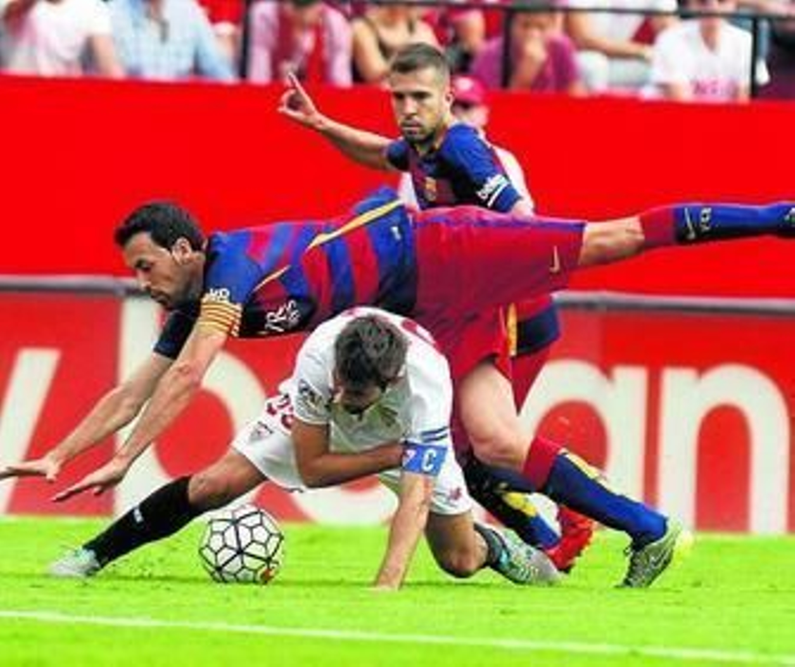 Coke aguanta como puede la entrada de Busquets ante Jordi Alba, que parece reclamar que no es falta.