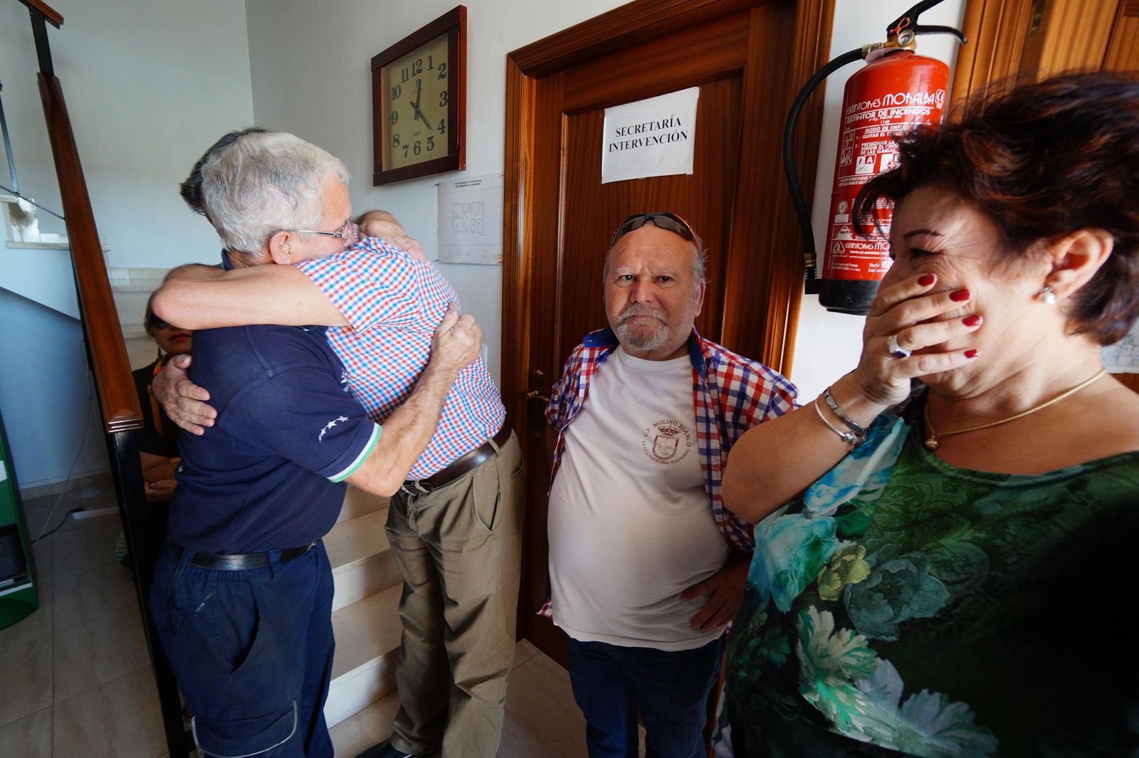 El alcalde de La Guijarrosa se abraza a un vecino ante la mirada emocionada de una mujer.