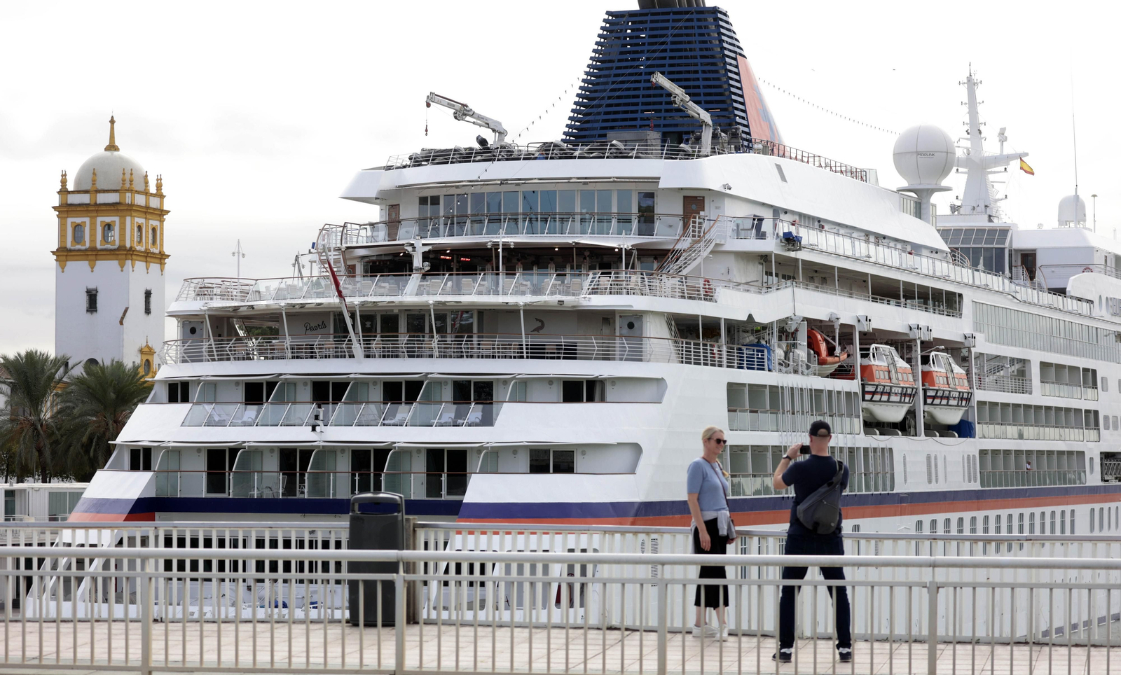 Una pareja se fotografía ante el crucero 'Europa', atracado en el Muelle de las Delicias. Una pareja se fotografía ante el crucero 'Europa', atracado en el Muelle de las Delicias.