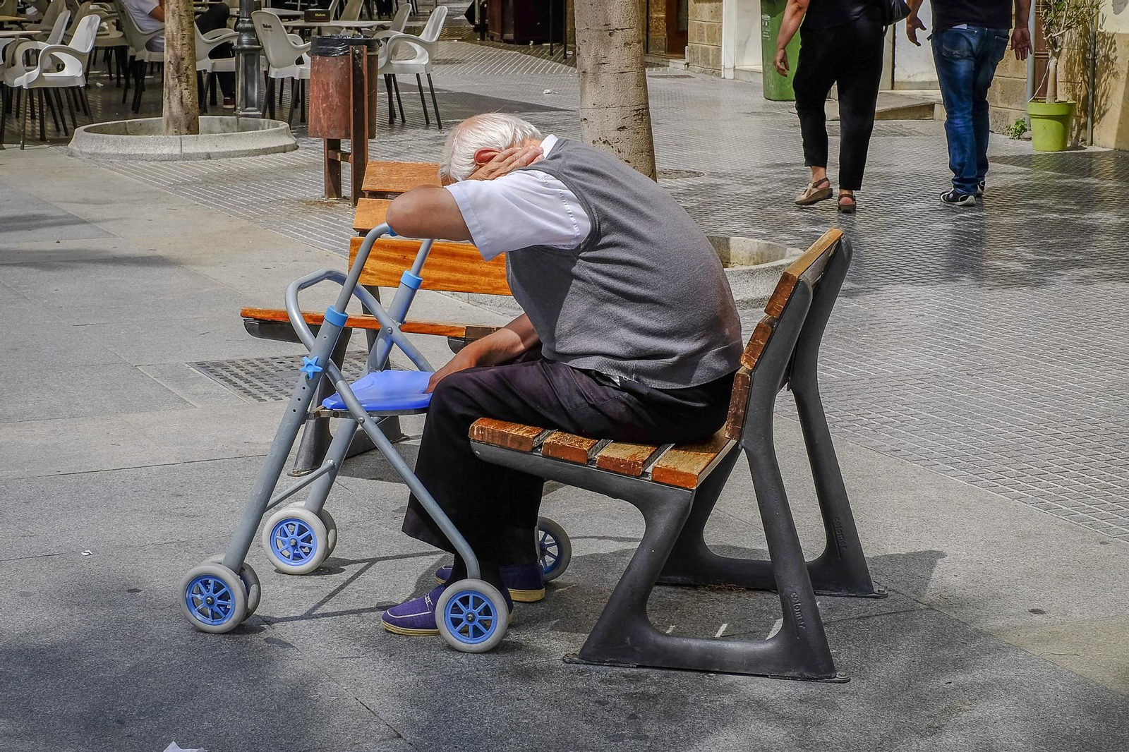 Una persona mayor sentada en la plaza de San Juan de Dios.