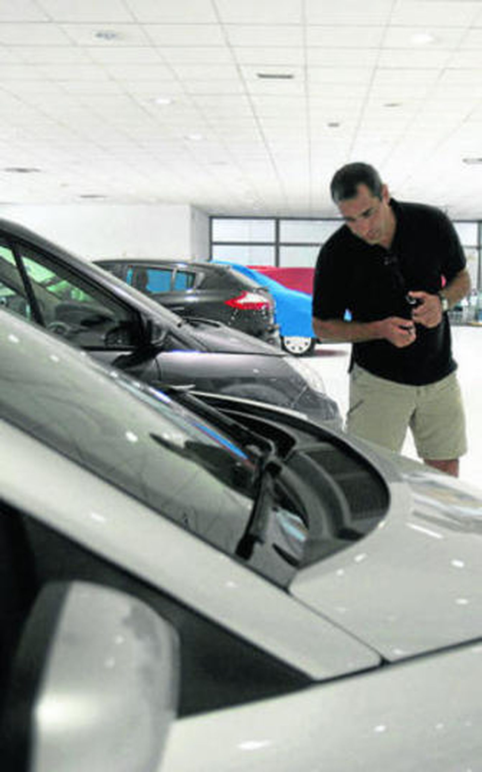 Un cliente observa un vehículo en un concesionario.