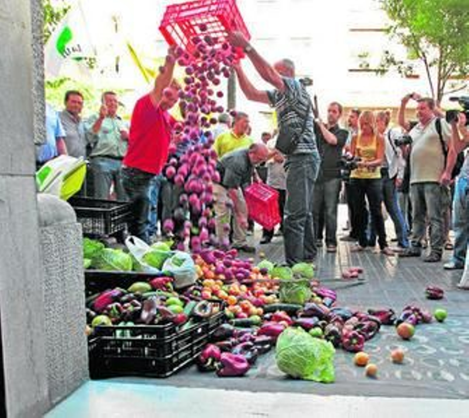 Un grupo de agricultores protesta ante el Consulado de Alemania en Valencia tirando 300 kilos de hortalizas.