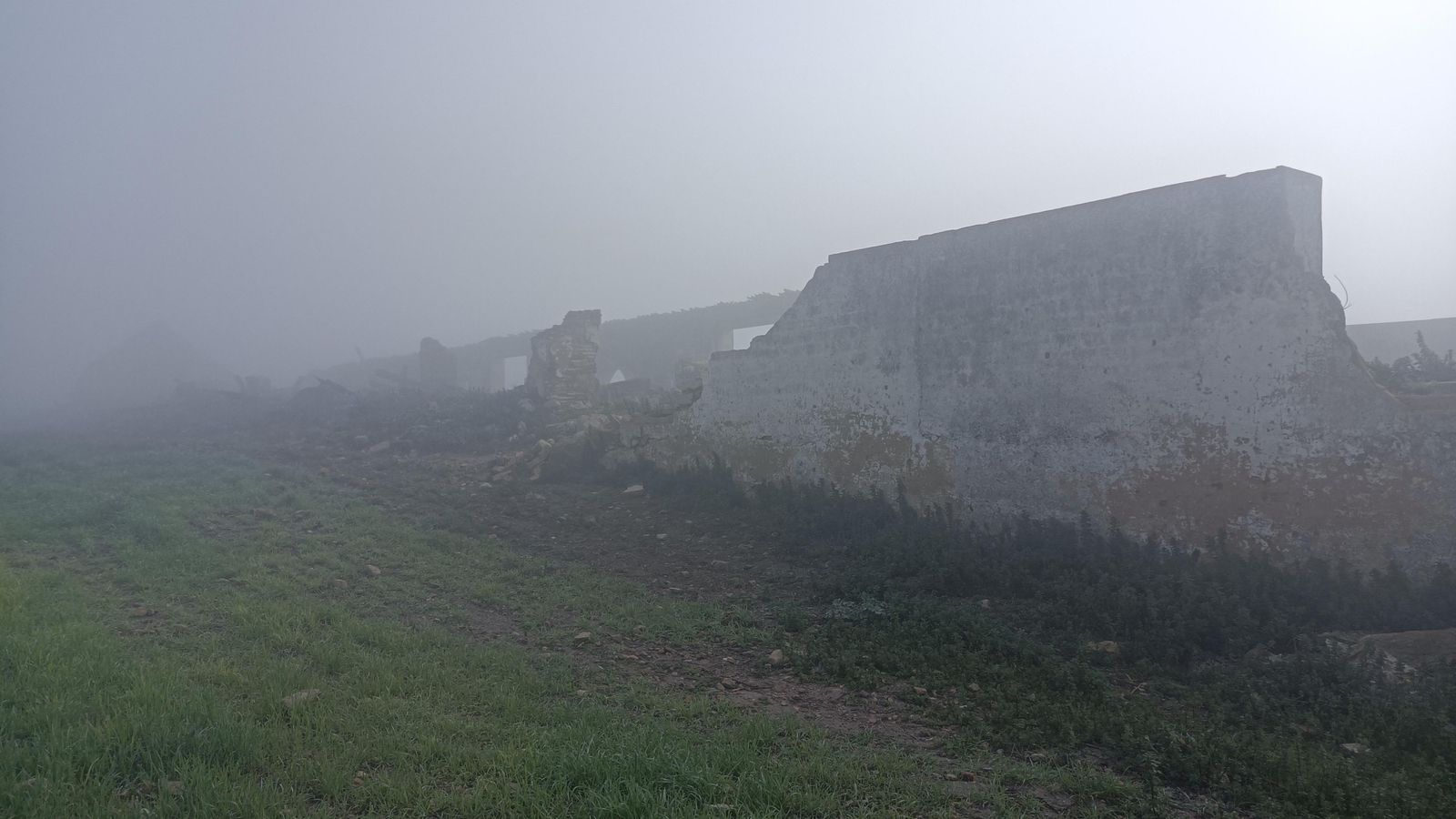 Entre la niebla, los restos del Cortijo de los Pardales.