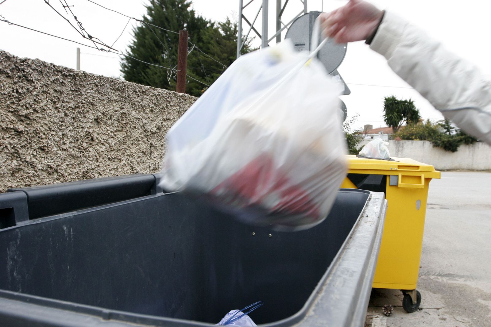 Una persona deposita una bolsa de basura en un contenedor, en una imagen de archivo.