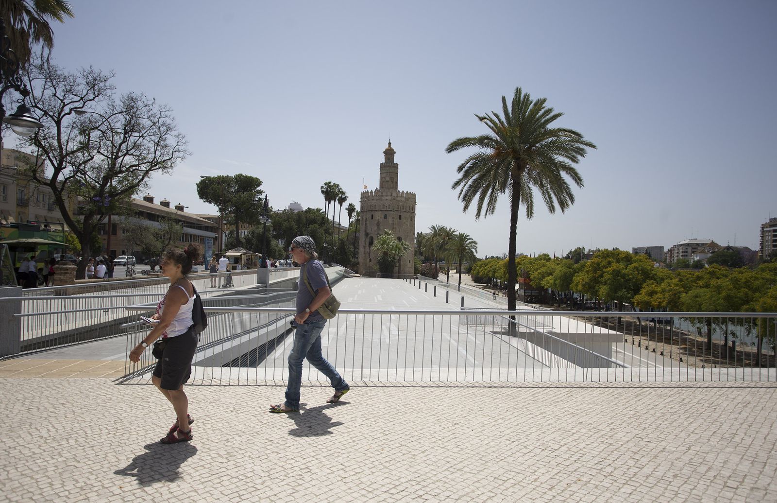 Dos turistas pasean bajo el sol por el nivel superior del paseo Marqués de Contadero.