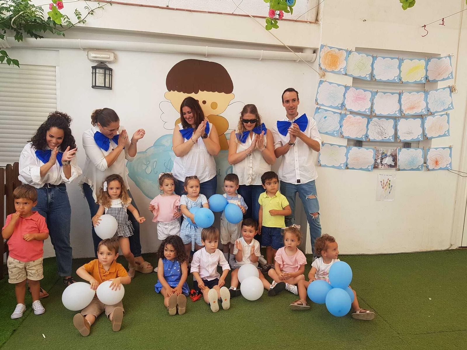 El alumnado de 'El Ángel de la Guarda' con personal del centro junto a algunos de sus trabajos.