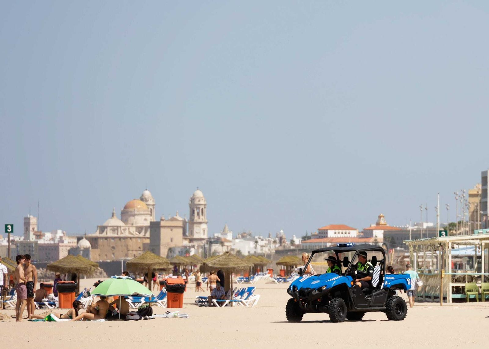 Dos agentes de la Policía Local de Cádiz patrullan por la playa.