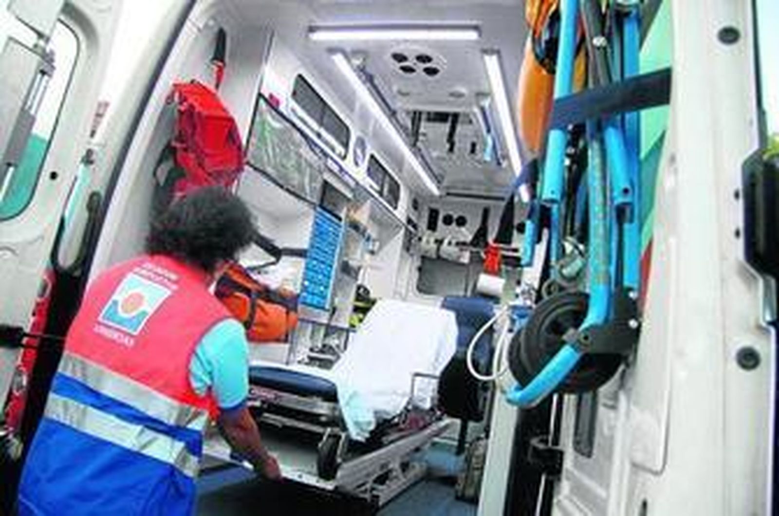 Un profesional sanitario saca una camilla de un vehículo de emergencias.