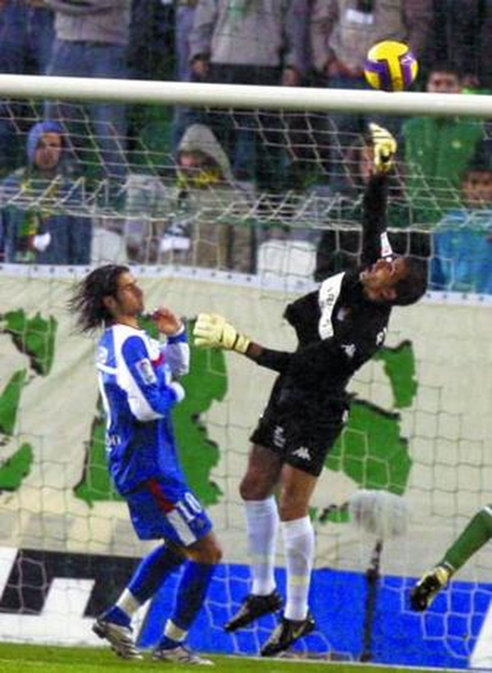 Ricardo desvía un lanzamiento, obstaculizado por Rubén de la Red.