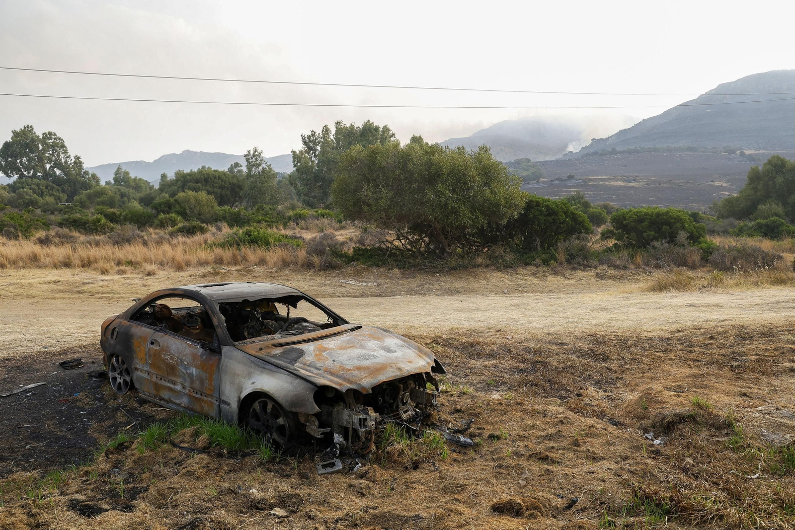 Un coche quemado en la zona afectada por el incendio en Tarifa.