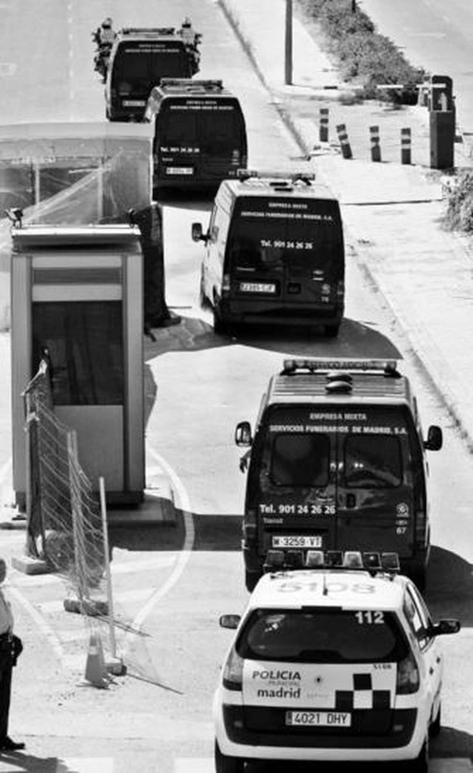 Furgones funerarios escoltados por la Policía trasladan los restos de las víctimas del accidente.