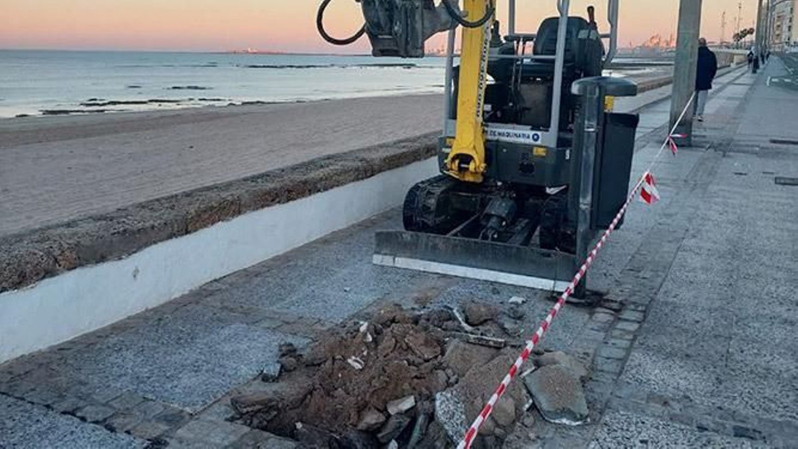 Una máquina abre un hueco para un árbole en el Paseo Marítimo de Cádiz.