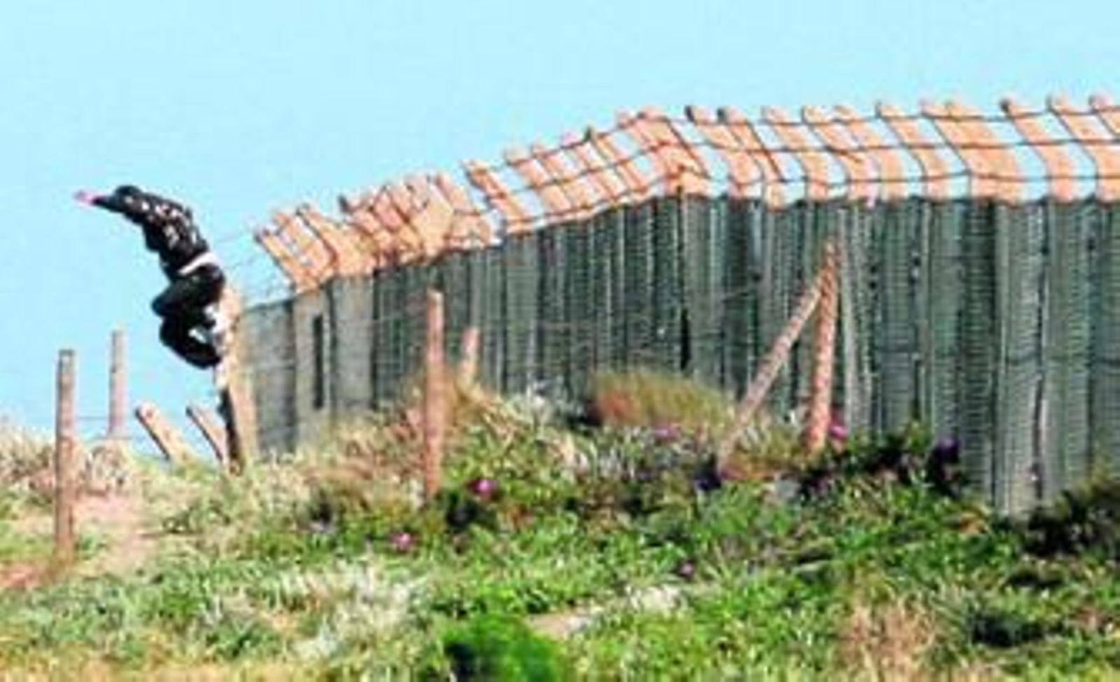 Un joven salta la Verja que separa Gibraltar y La Línea, a la altura de Santa Bárbara.