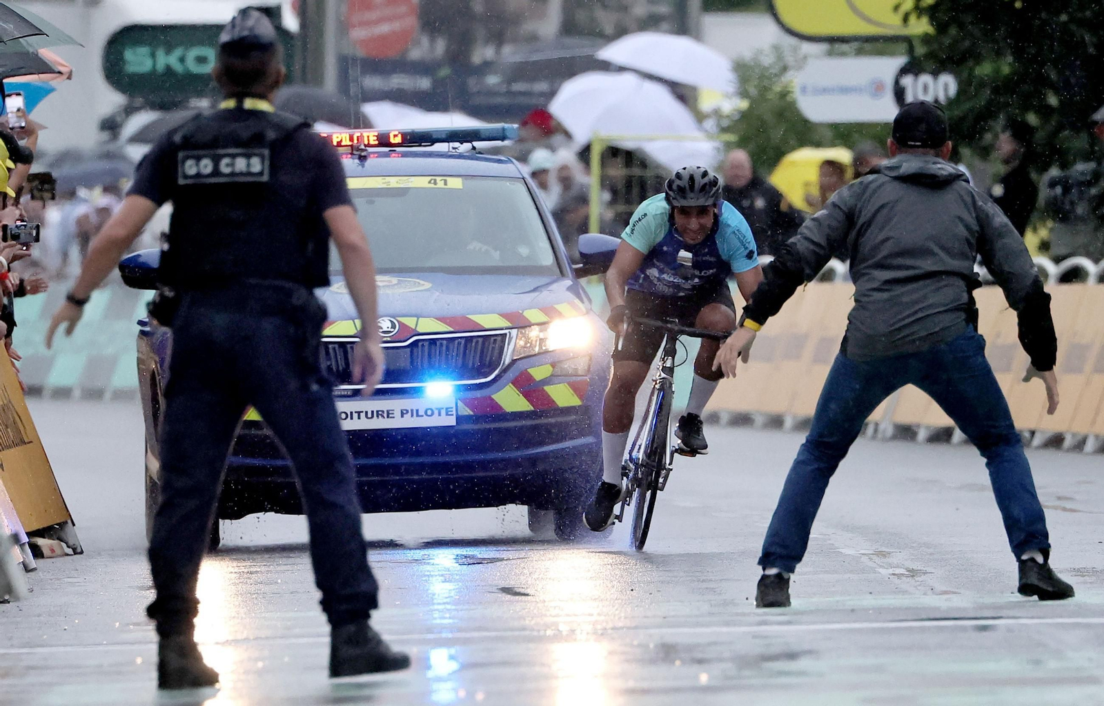 Los miembros de seguridad detienen a un ciclista que entró en la línea de meta antes del esprint final.